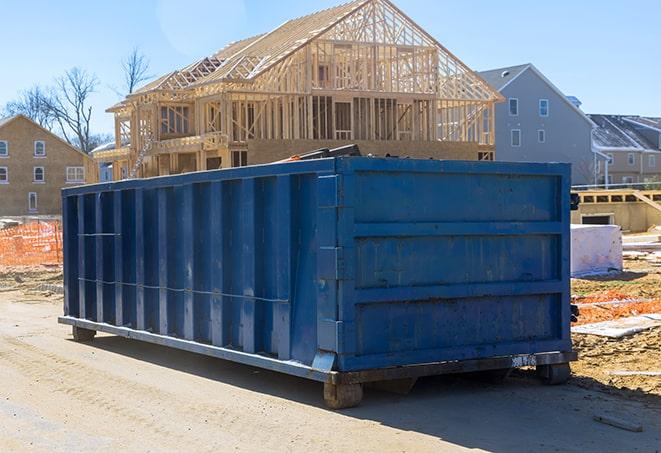 shingles and roofing materials piled high in a dumpster